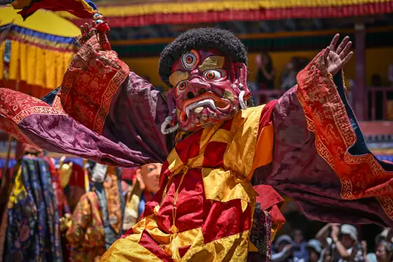 Close-up of a masked festival performer in traditional dress