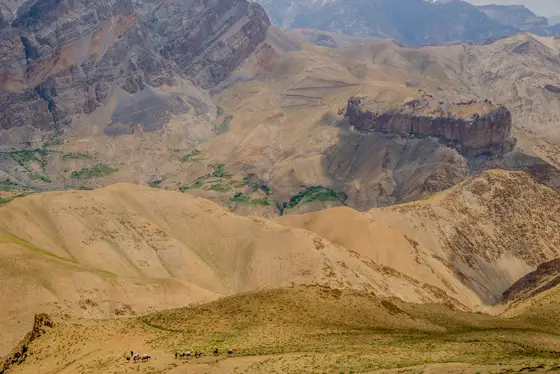 High desert valley panorama with distant green patches and cliffs