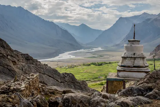 Hillside monastery and prayer flags above a rocky Ladakh village