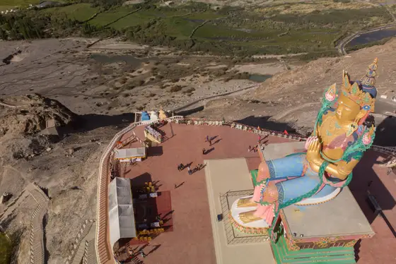 Large Maitreya statue overlooking a broad Ladakh valley