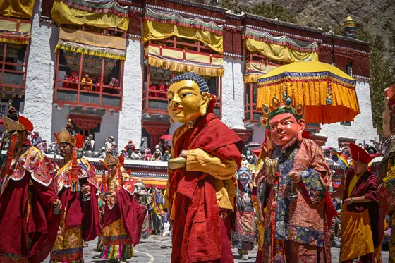 Masked monastic festival performers in a Ladakh monastery courtyard