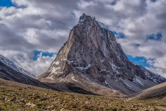 Towering mountain peak under dramatic clouds in Ladakh